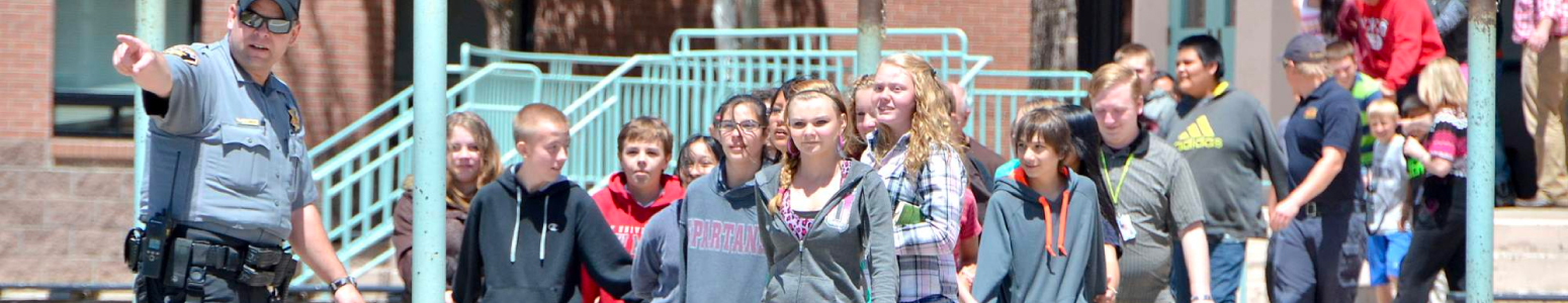 Officer instructing students on where to go and what to do during a drill