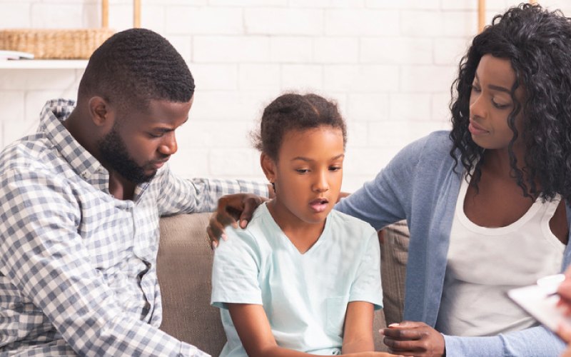 Two parents consoling their child battling behavioral health