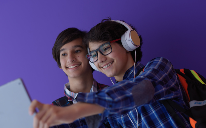 Two middle school students share a laptop