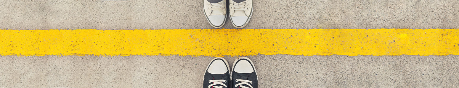 students stading on either side of yellow parking lot stripe